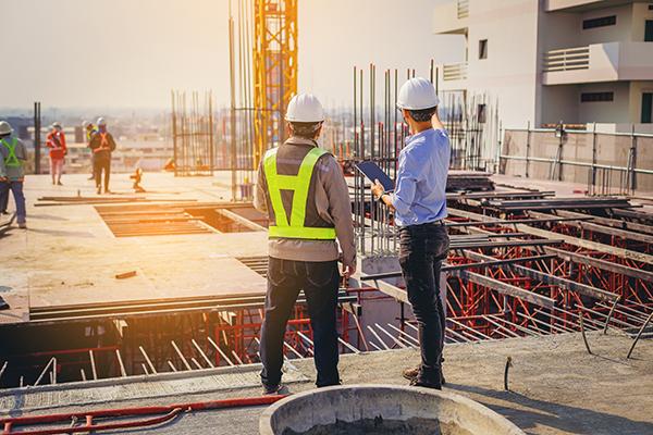 two workers looking at construction site